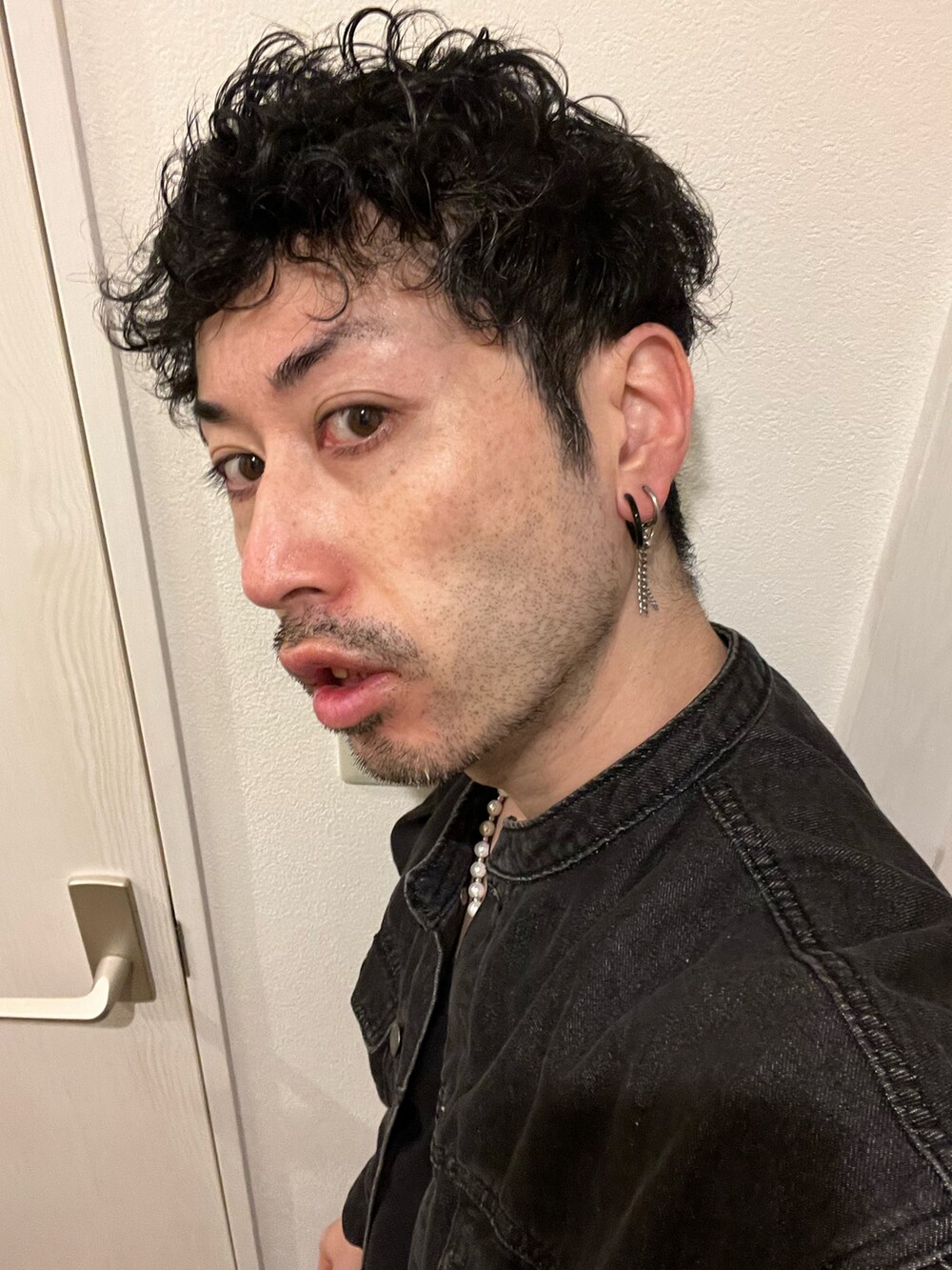 ブルー系のデニムパンツ、ブラック系のスニーカー、ブラック系のデニムジャケットを着用したメンズの冬コーディネートの5枚目の写真