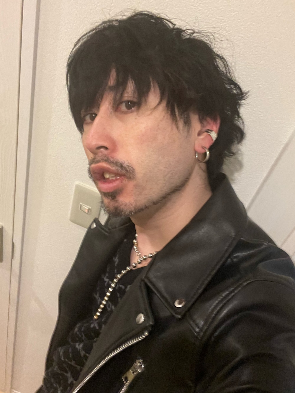 ブラック系のライダースジャケット、ブラック系のその他パンツ、ブラック系のサンダルを着用したメンズの春コーディネートの5枚目の写真
