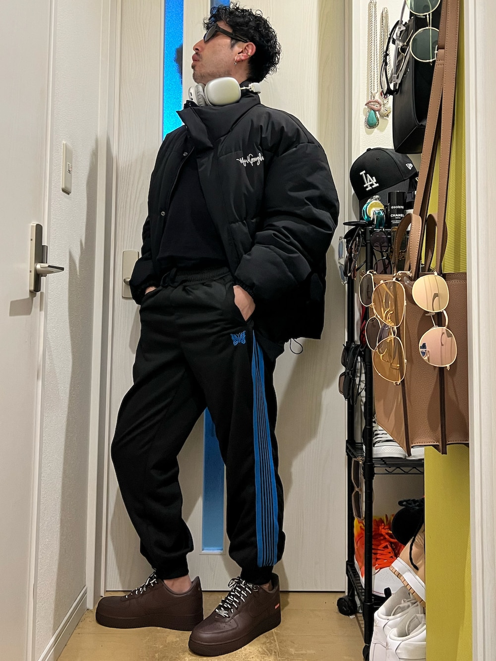 ブラック系のダウンジャケット/コート、ブラウン系のスニーカーを着用したメンズの冬コーディネートの2枚目の写真