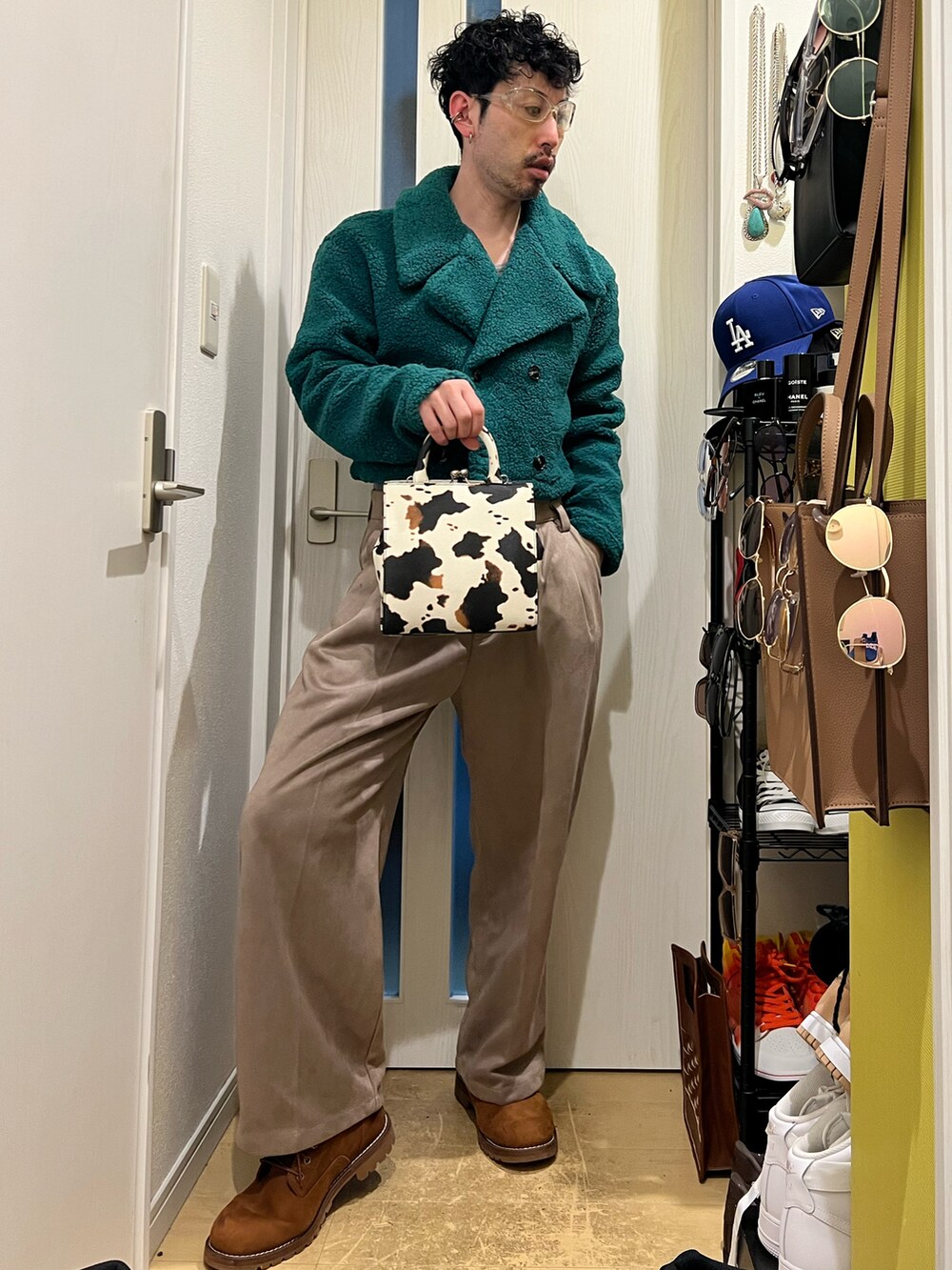 グリーン系のジャケット/アウター、ホワイト系のショルダーバッグ、ベージュ系のスラックスを着用したメンズの冬コーディネートの4枚目の写真