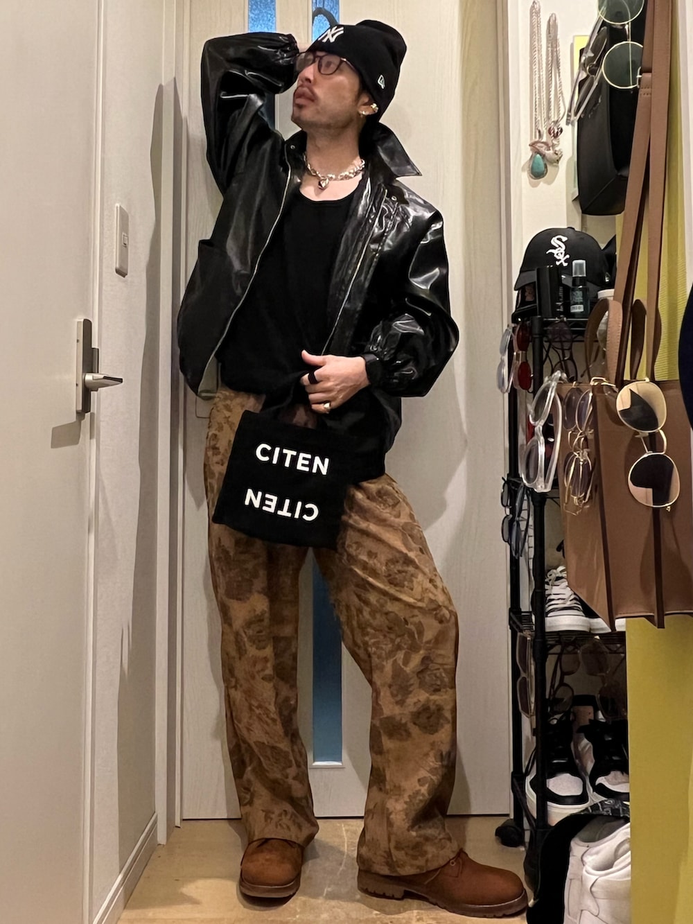 ブラック系のトートバッグ、ブラウン系のその他パンツ、ブラウン系のブーツを着用したメンズの秋コーディネートの3枚目の写真