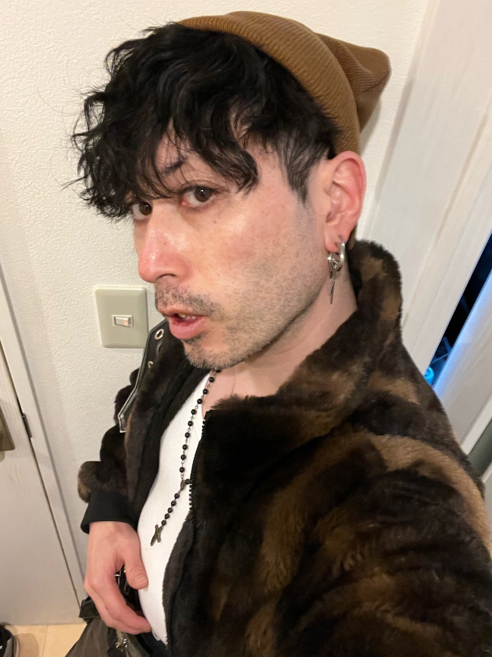 ブラック系のハンドバッグ、ブラック系のデニムパンツ、ブラウン系のブーツを着用したメンズの冬コーディネートの5枚目の写真