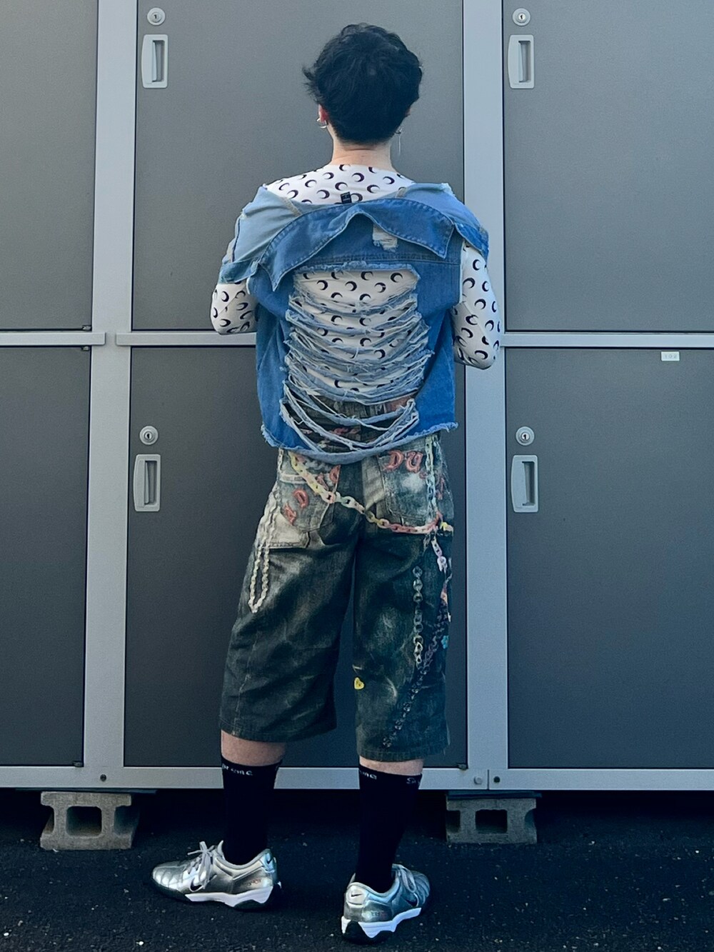 ブルー系のデニムパンツ、シルバー系のスニーカー、ブラック系のショルダーバッグを着用したメンズの夏コーディネートの3枚目の写真