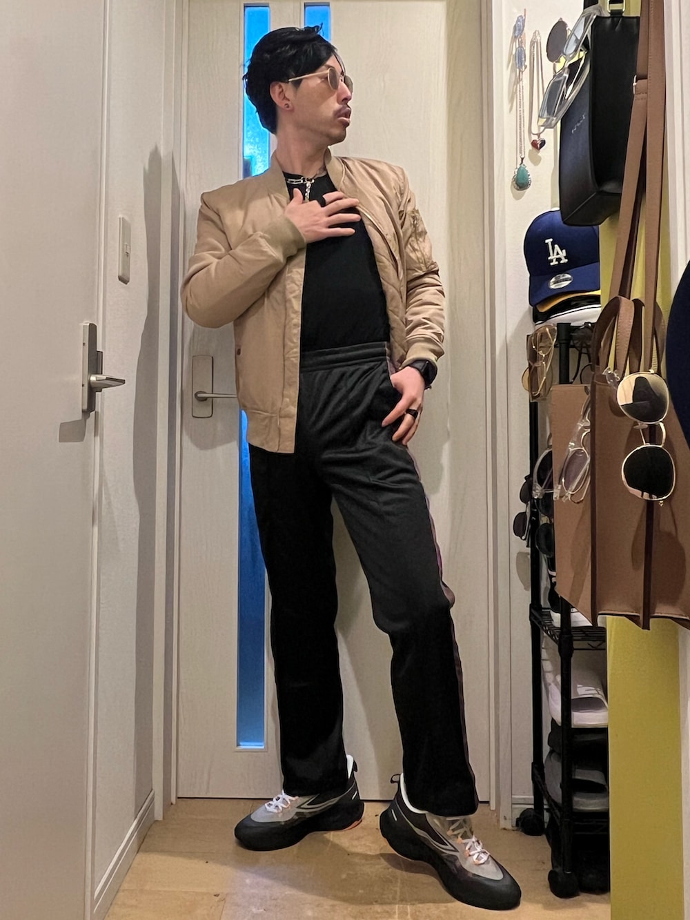 ベージュ系のMA-1、ブラック系のデニムパンツ、ブラック系のスニーカーを着用したメンズの春コーディネートの3枚目の写真