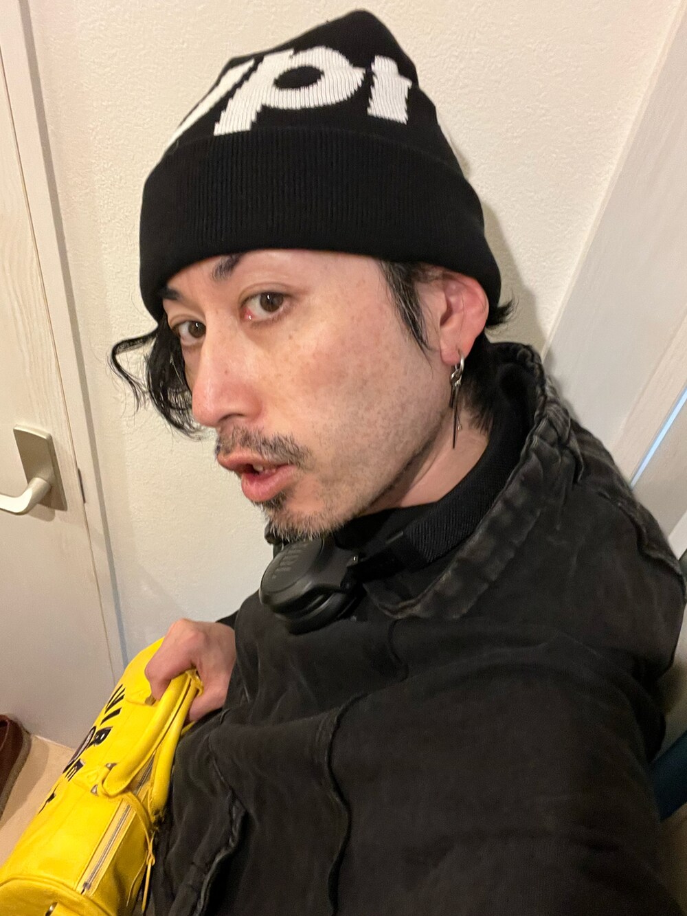 イエロー系のボストンバッグ、ブルー系のカーゴパンツ、ブラック系のブーツを着用したメンズの冬コーディネートの5枚目の写真