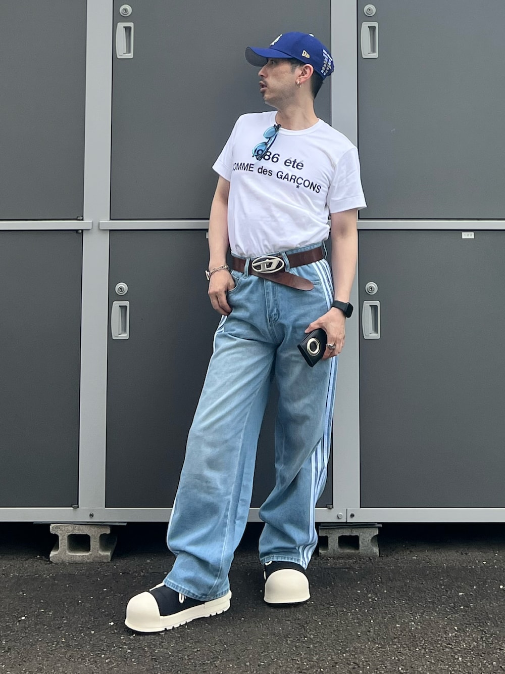 ホワイト系のTシャツ/カットソー、ブルー系のデニムパンツ、ブラック系のスニーカーを着用したメンズの夏コーディネートの2枚目の写真