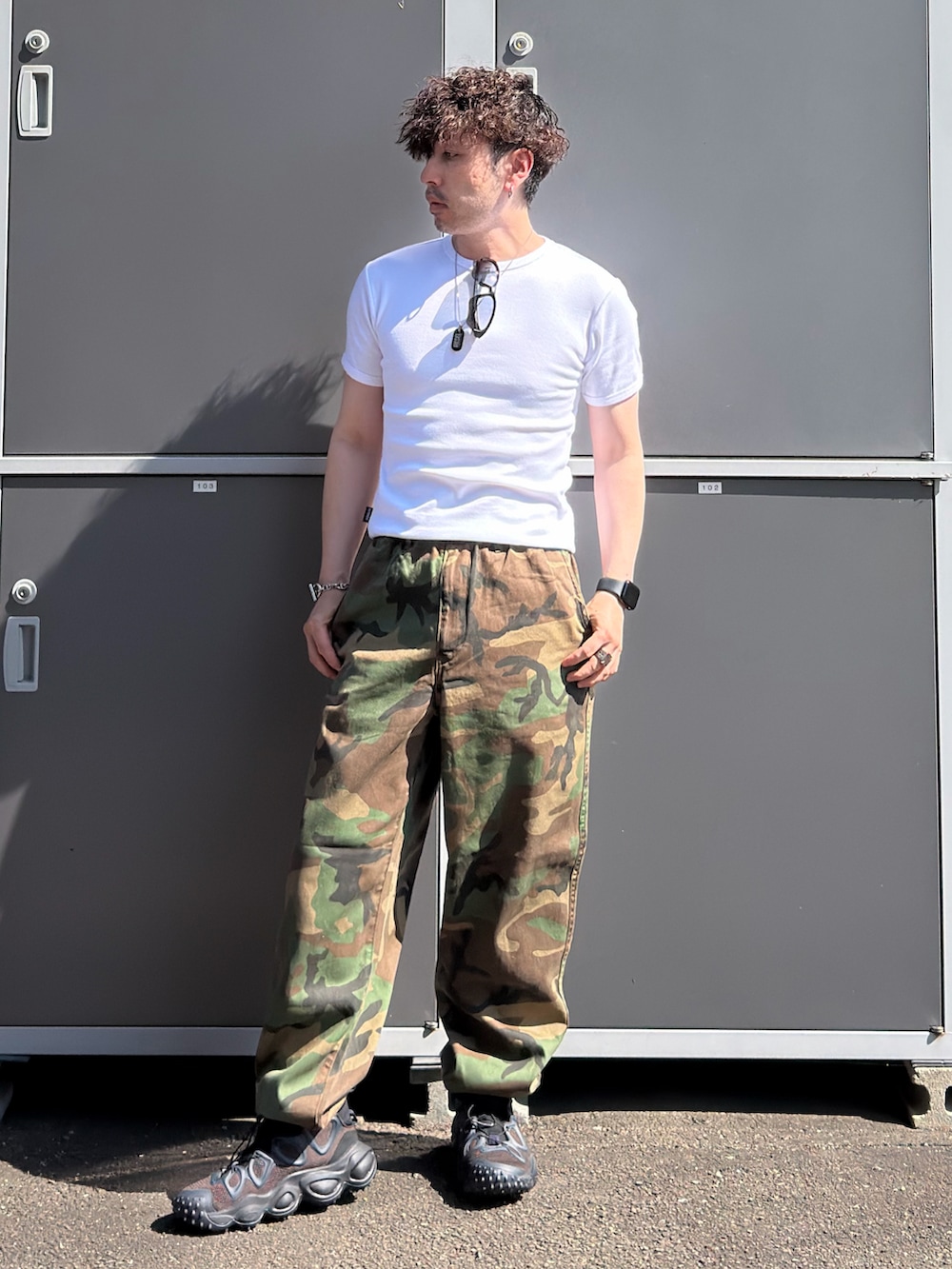 ホワイト系のTシャツ/カットソー、グリーン系のその他パンツ、ブラック系のスニーカーを着用したメンズの秋コーディネートの2枚目の写真