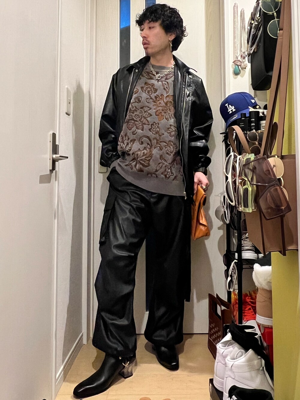 グレー系のニット/セーター、イエロー系のハンドバッグ、ブラック系のブルゾンを着用したメンズの春コーディネートの3枚目の写真