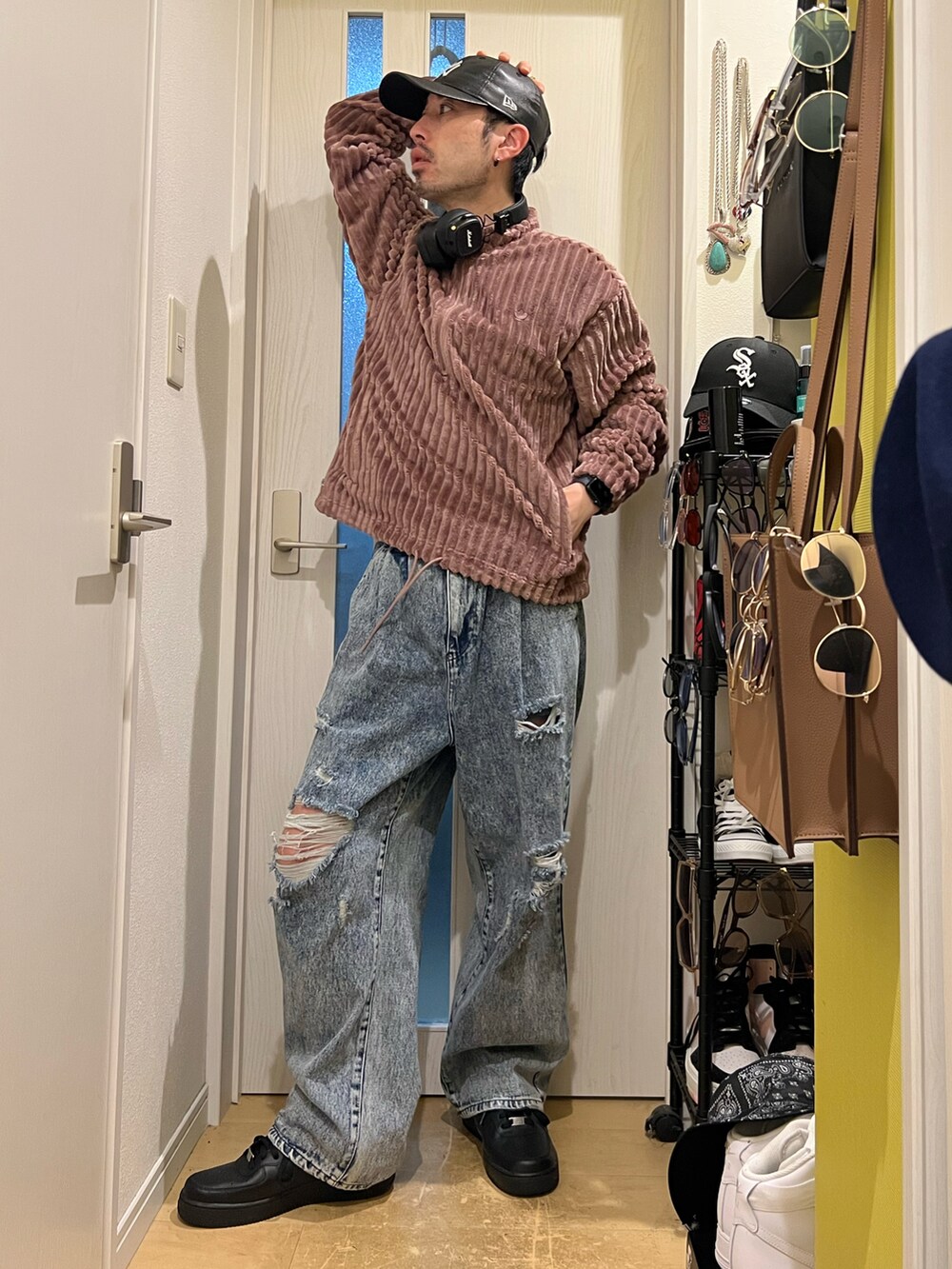 ブルー系のデニムパンツ、ブラック系のスニーカー、ブラウン系のスウェットを着用したメンズの秋コーディネートの3枚目の写真