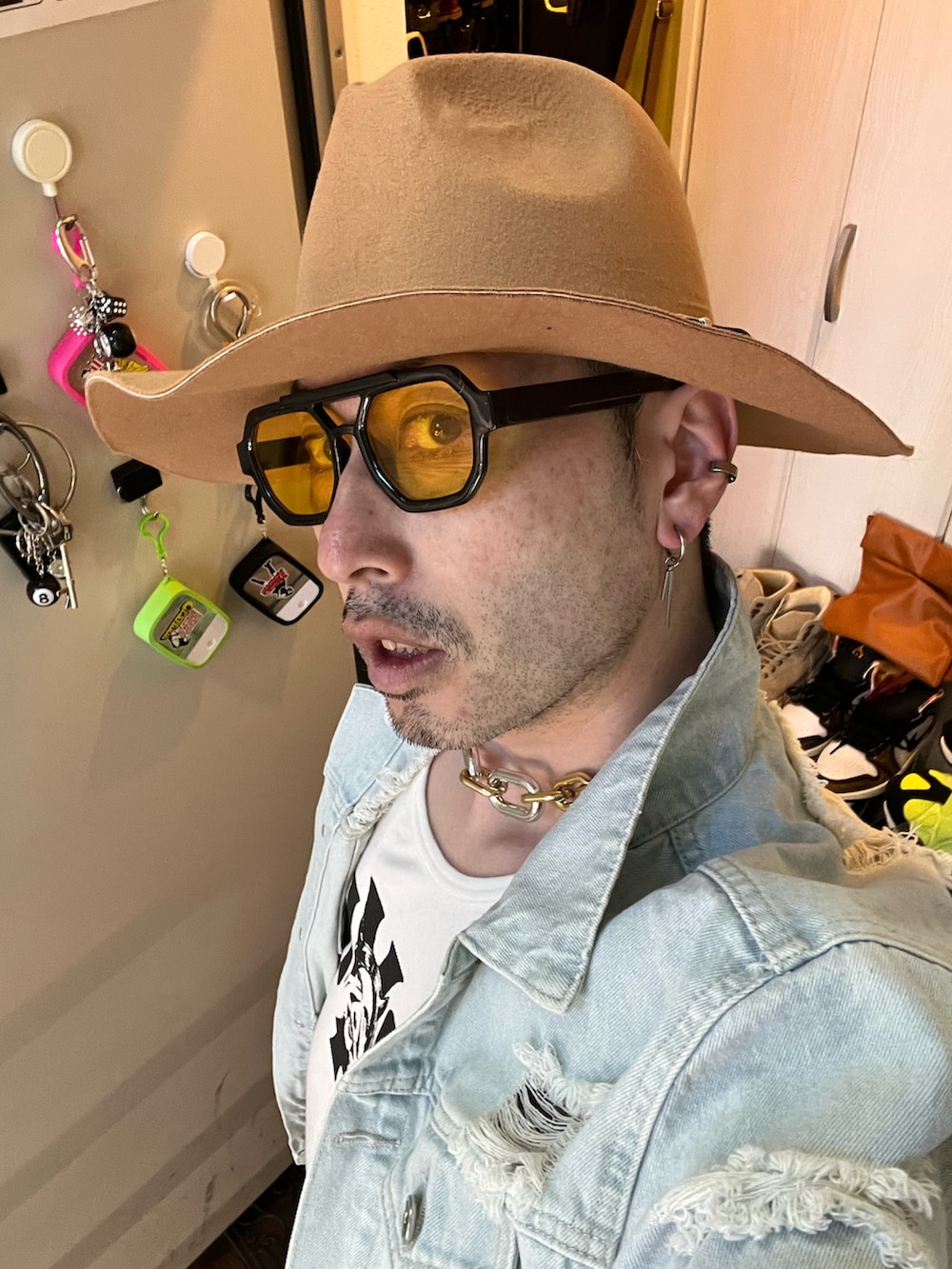 ホワイト系のタンクトップ、ブラック系のショルダーバッグ、その他のデニムパンツを着用したメンズの春コーディネートの4枚目の写真