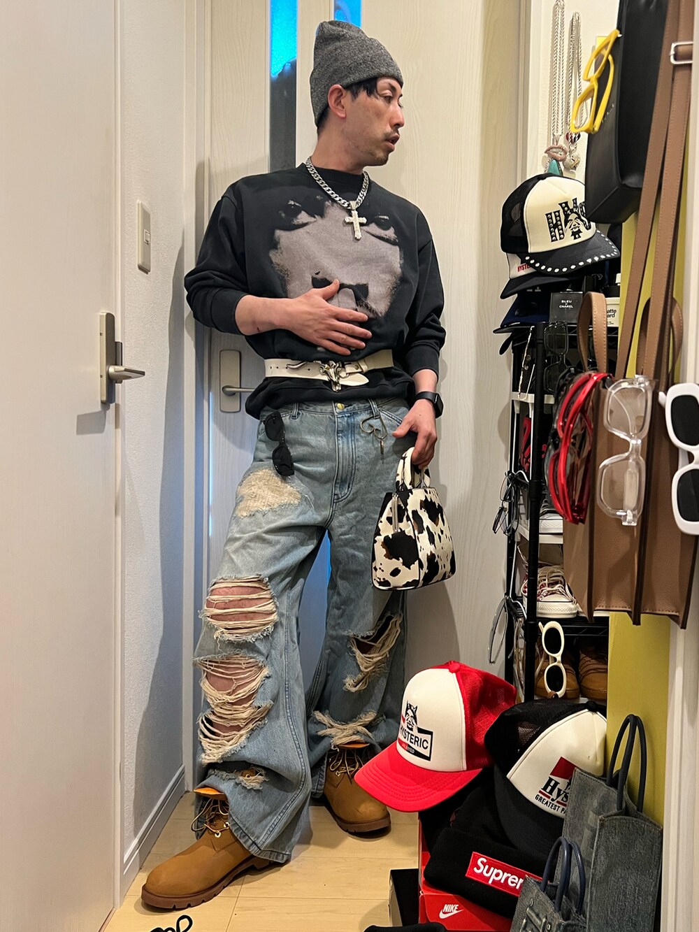 ブルー系のデニムパンツ、ホワイト系のショルダーバッグ、ブラック系のスウェットを着用したメンズの冬コーディネートの2枚目の写真