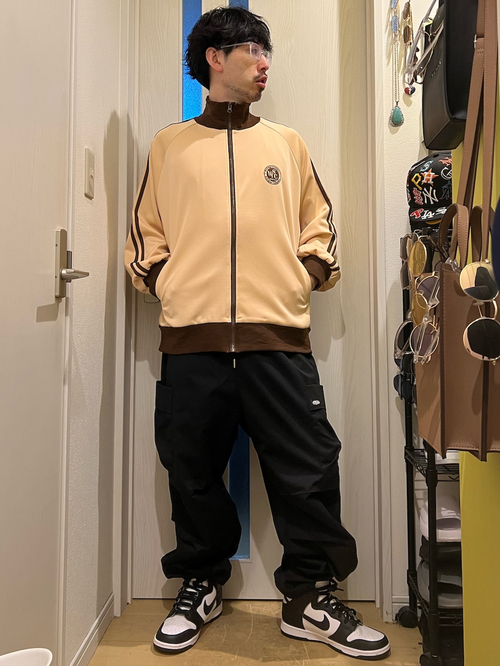 ベージュ系のその他アウター、ブラック系のカーゴパンツ、ホワイト系のスニーカーを着用したメンズの春コーディネートの2枚目の写真