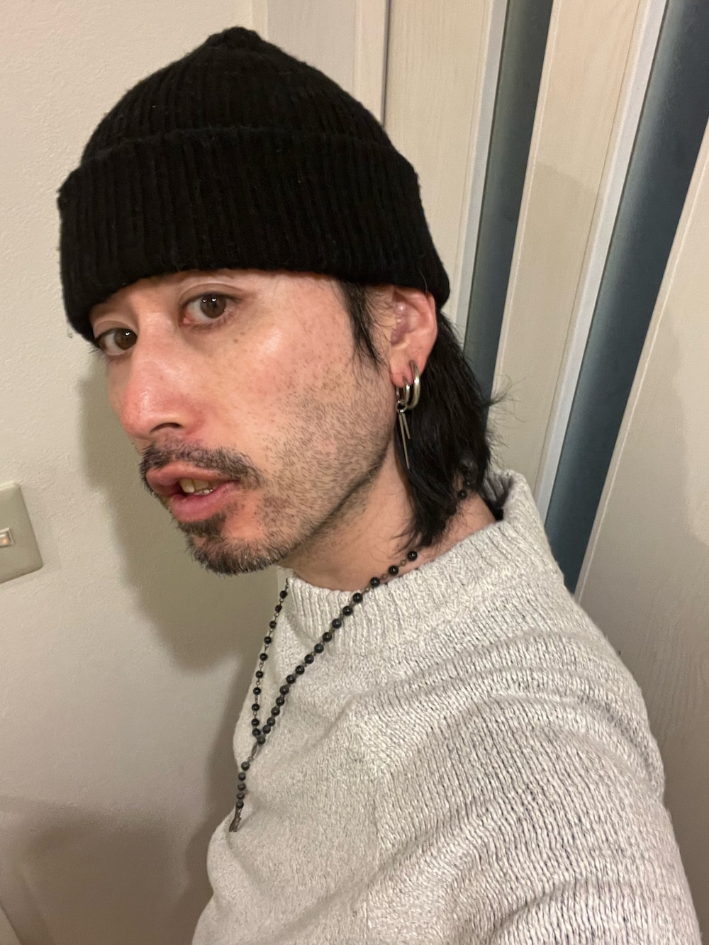 ホワイト系のニット/セーター、ブラック系のブーツを着用したメンズの冬コーディネートの3枚目の写真