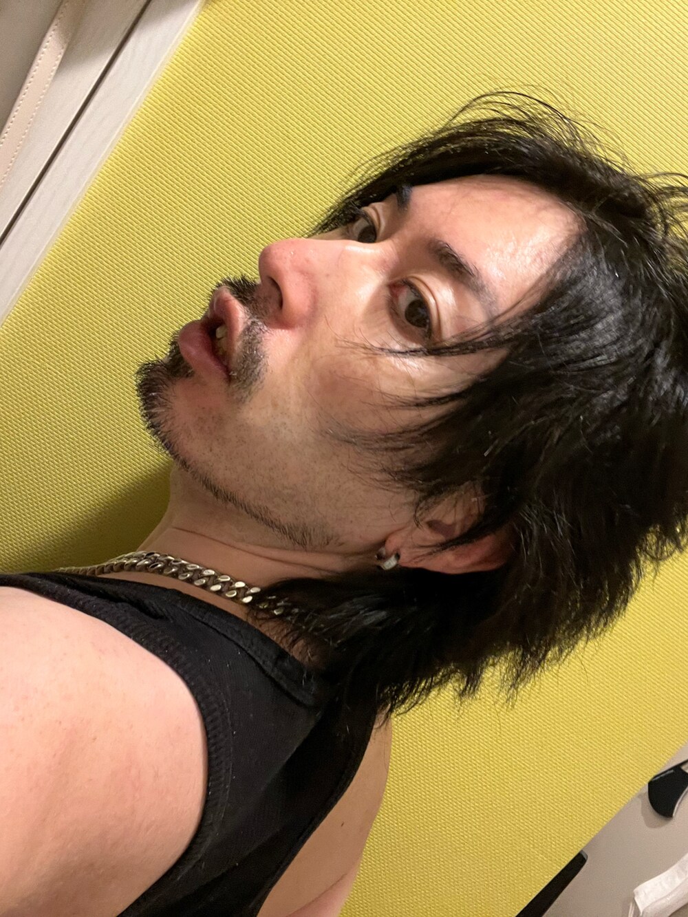 ブラック系のブーツ、グレー系のスラックス、レッド系のカーディガン/ボレロを着用したメンズの冬コーディネートの5枚目の写真