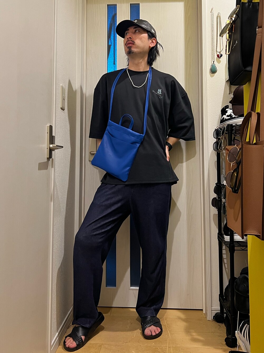 グリーン系のショルダーバッグ、ブラック系のTシャツ/カットソー、ブラック系のサンダルを着用したメンズの夏コーディネートの3枚目の写真