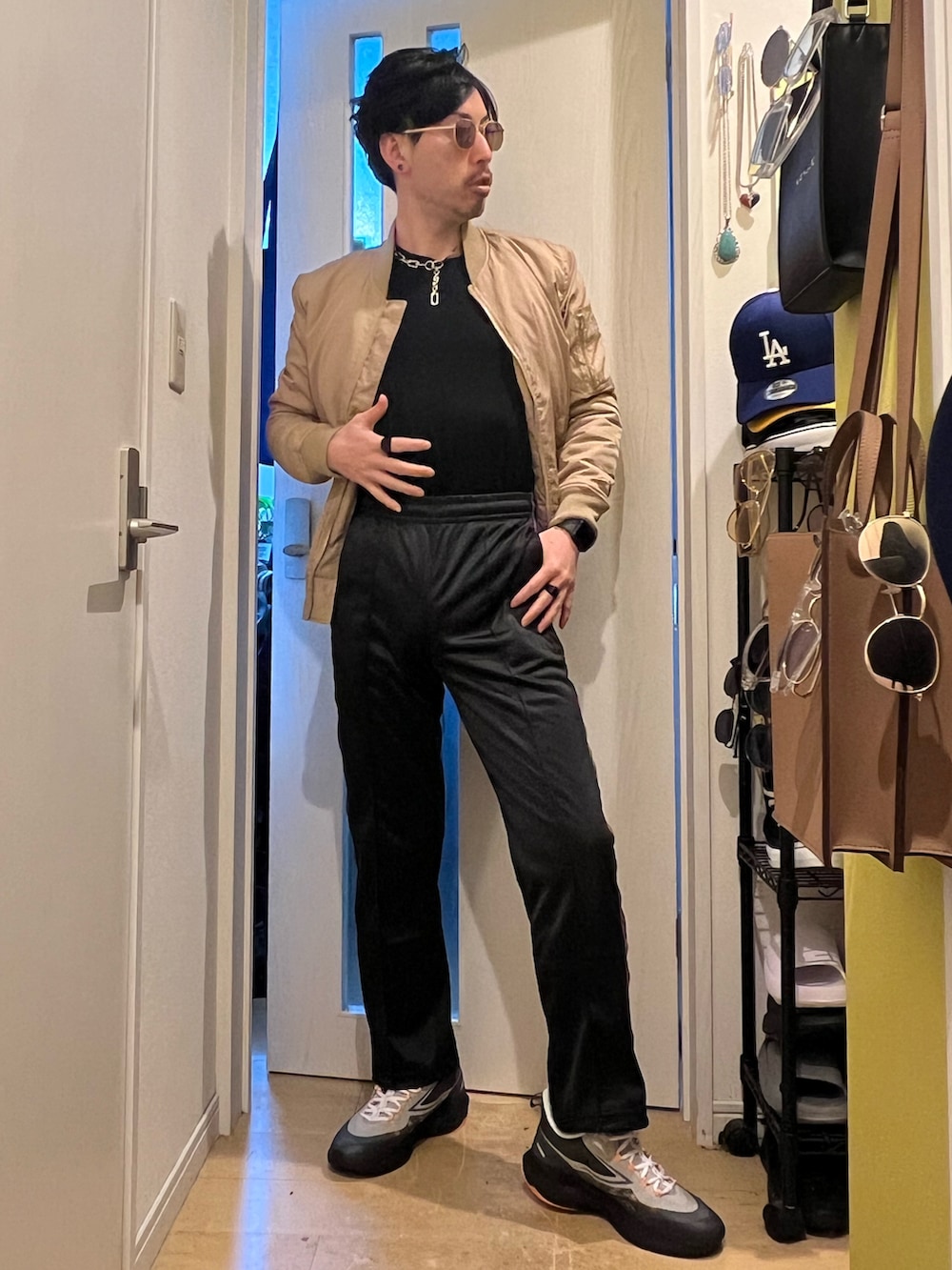 ベージュ系のMA-1、ブラック系のデニムパンツ、ブラック系のスニーカーを着用したメンズの春コーディネートの2枚目の写真