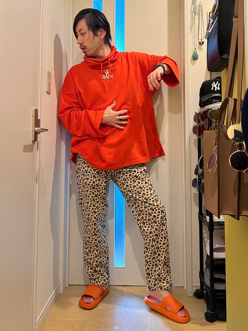 その他のチノパンツ、オレンジ系のスウェットを着用したメンズの冬コーディネートの2枚目の写真