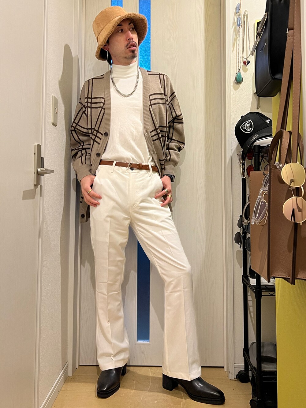 ホワイト系のショルダーバッグ、ベージュ系のカーディガン/ボレロ、ホワイト系のスラックスを着用したメンズの秋コーディネートの3枚目の写真