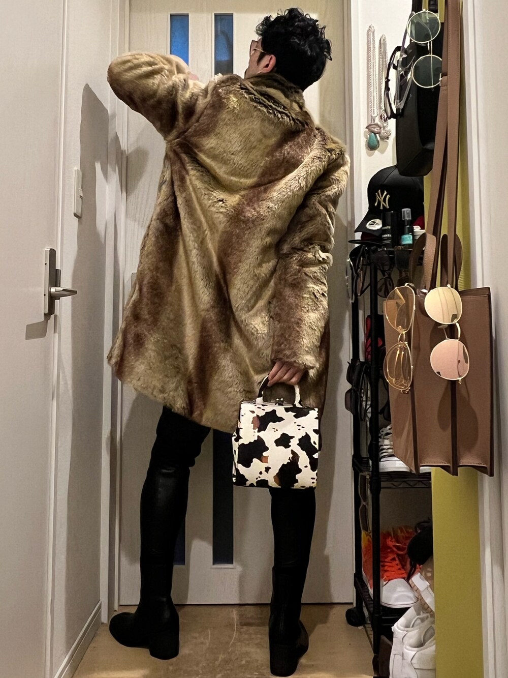 ブラック系のスウェットパンツ、ブラック系のブーツ、ホワイト系のショルダーバッグを着用したメンズの冬コーディネートの4枚目の写真