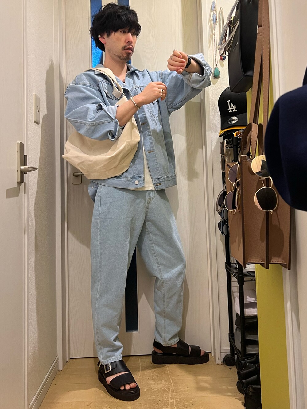 ブルー系のデニムジャケット、ブルー系のデニムパンツ、ブラック系のサンダルを着用したメンズの春コーディネートの2枚目の写真