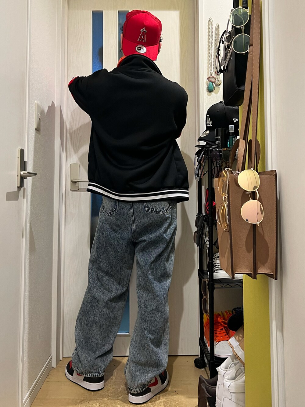 ブルー系のデニムパンツ、ブラック系のスニーカー、レッド系のジャケット/アウターを着用したメンズの冬コーディネートの4枚目の写真