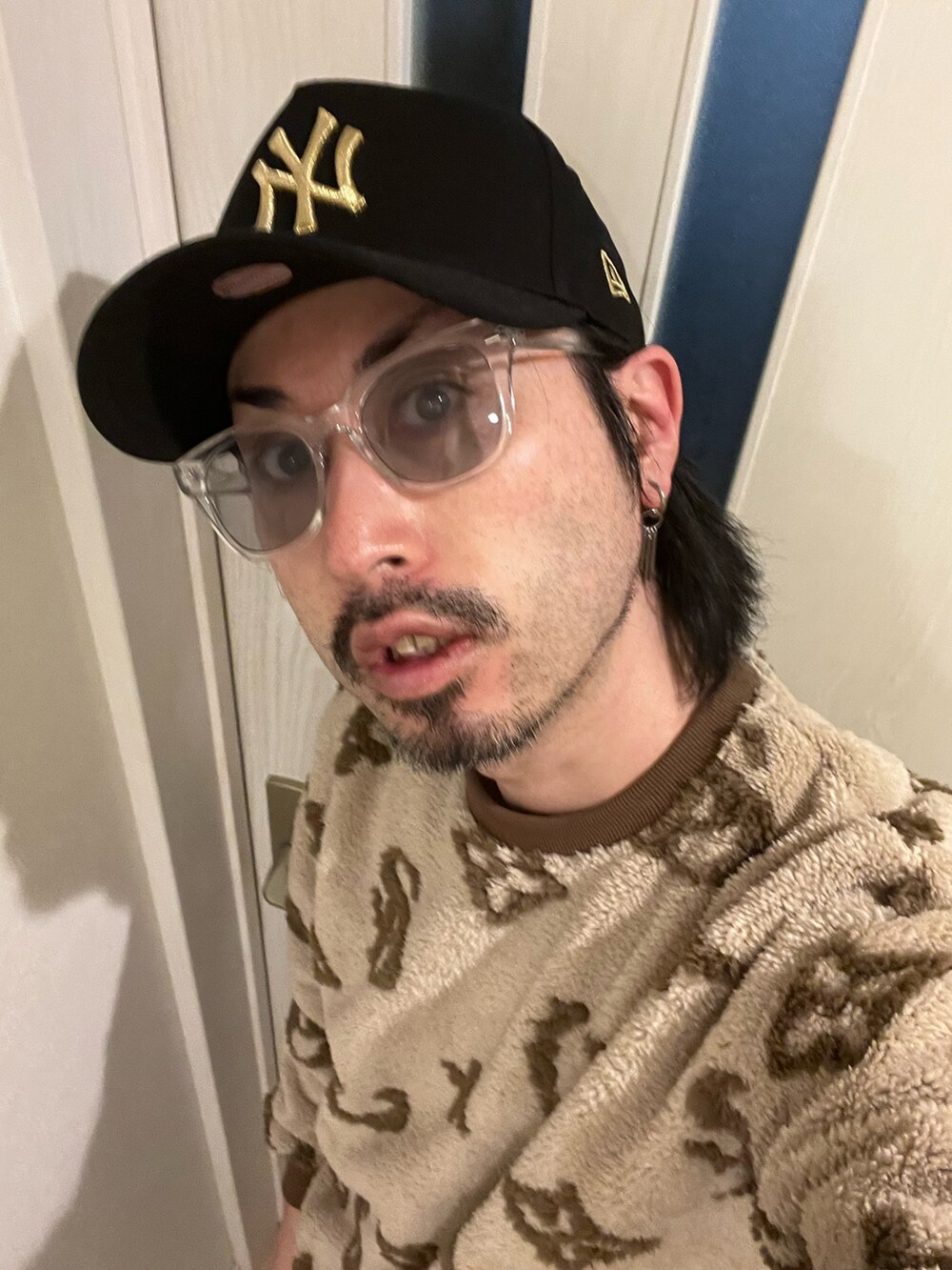 ブラック系のデニムパンツ、ベージュ系のスウェット、ホワイト系のスニーカーを着用したメンズの冬コーディネートの4枚目の写真