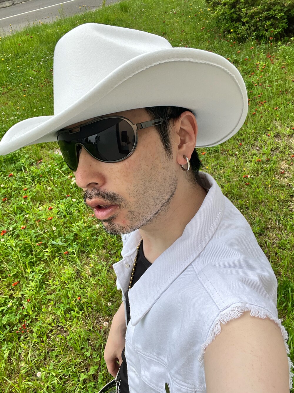 ブラック系のデニムパンツ、ブラック系のスニーカー、ブラック系のショルダーバッグを着用したメンズの夏コーディネートの5枚目の写真