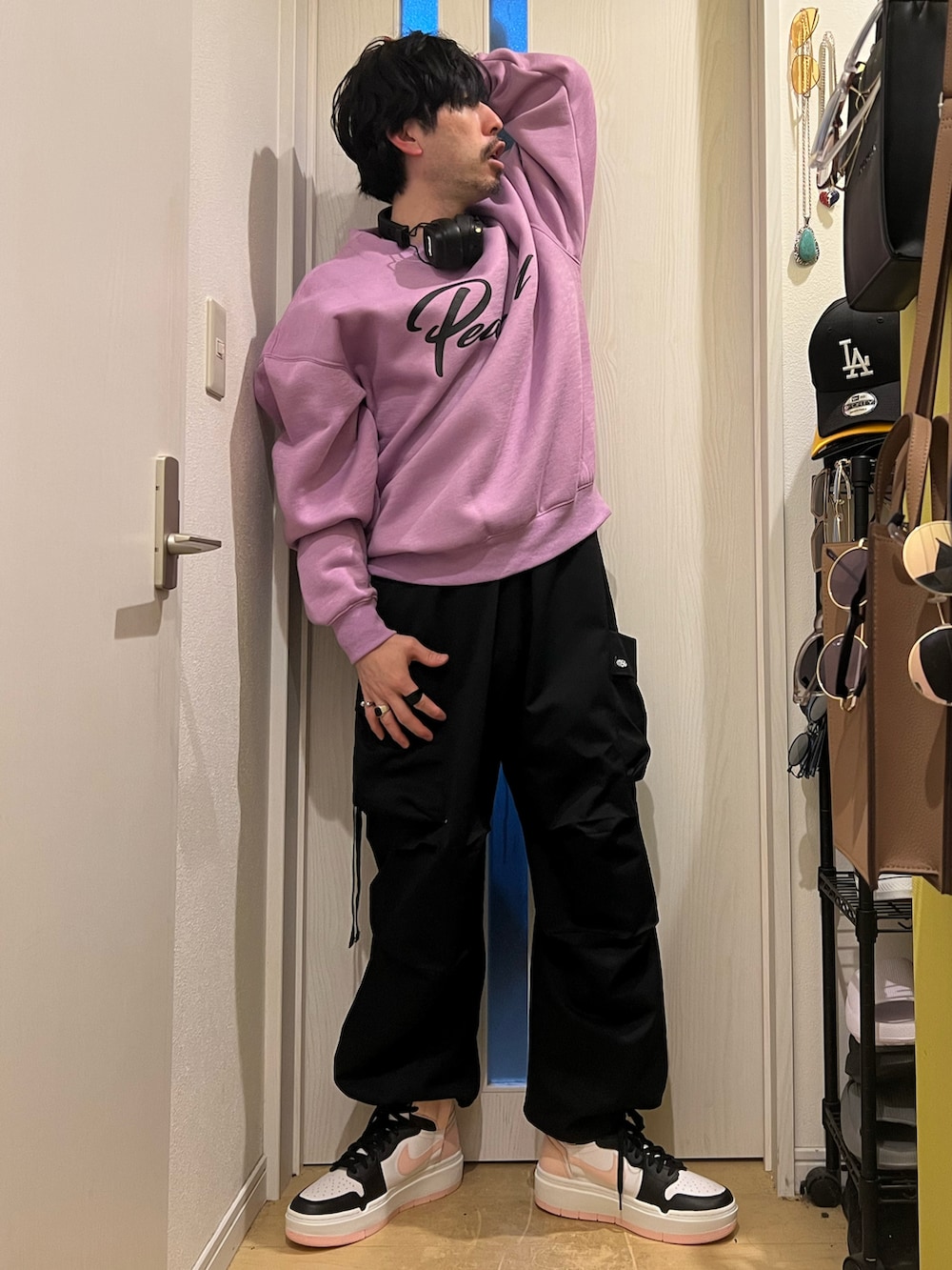 パープル系のスウェット、ブラック系のカーゴパンツ、ブラック系のスニーカーを着用したメンズの春コーディネートの3枚目の写真