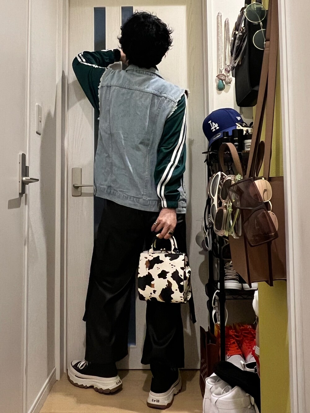 ブラック系のカーゴパンツ、ブラック系のスニーカー、ホワイト系のショルダーバッグを着用したメンズの春コーディネートの3枚目の写真