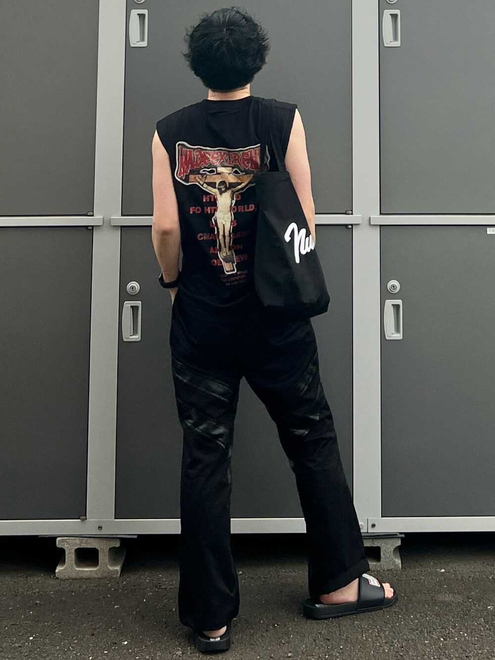 ブラック系のトートバッグ、ブラック系のタンクトップ、ブラック系のパンツを着用したメンズの夏コーディネートの3枚目の写真