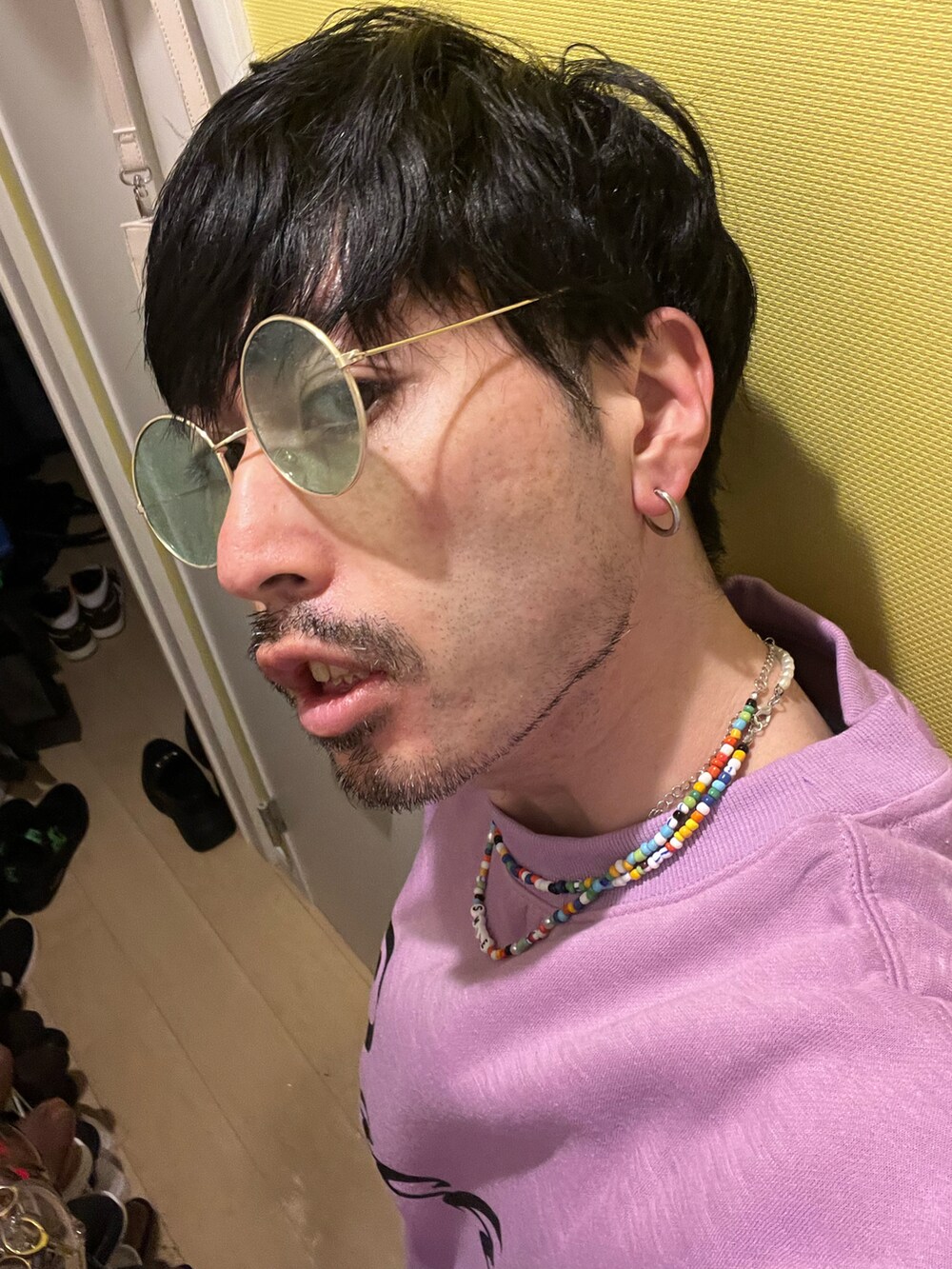 パープル系のスウェット、グレー系のデニムパンツ、ホワイト系のスニーカーを着用したメンズの春コーディネートの4枚目の写真