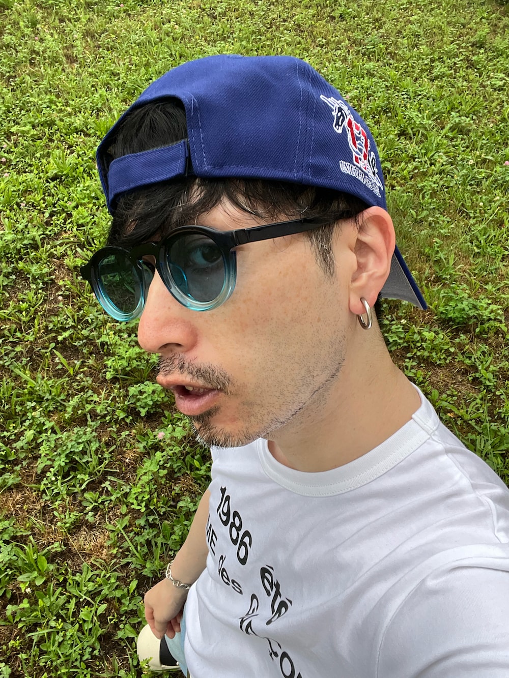 ホワイト系のTシャツ/カットソー、ブルー系のデニムパンツ、ブラック系のスニーカーを着用したメンズの夏コーディネートの4枚目の写真