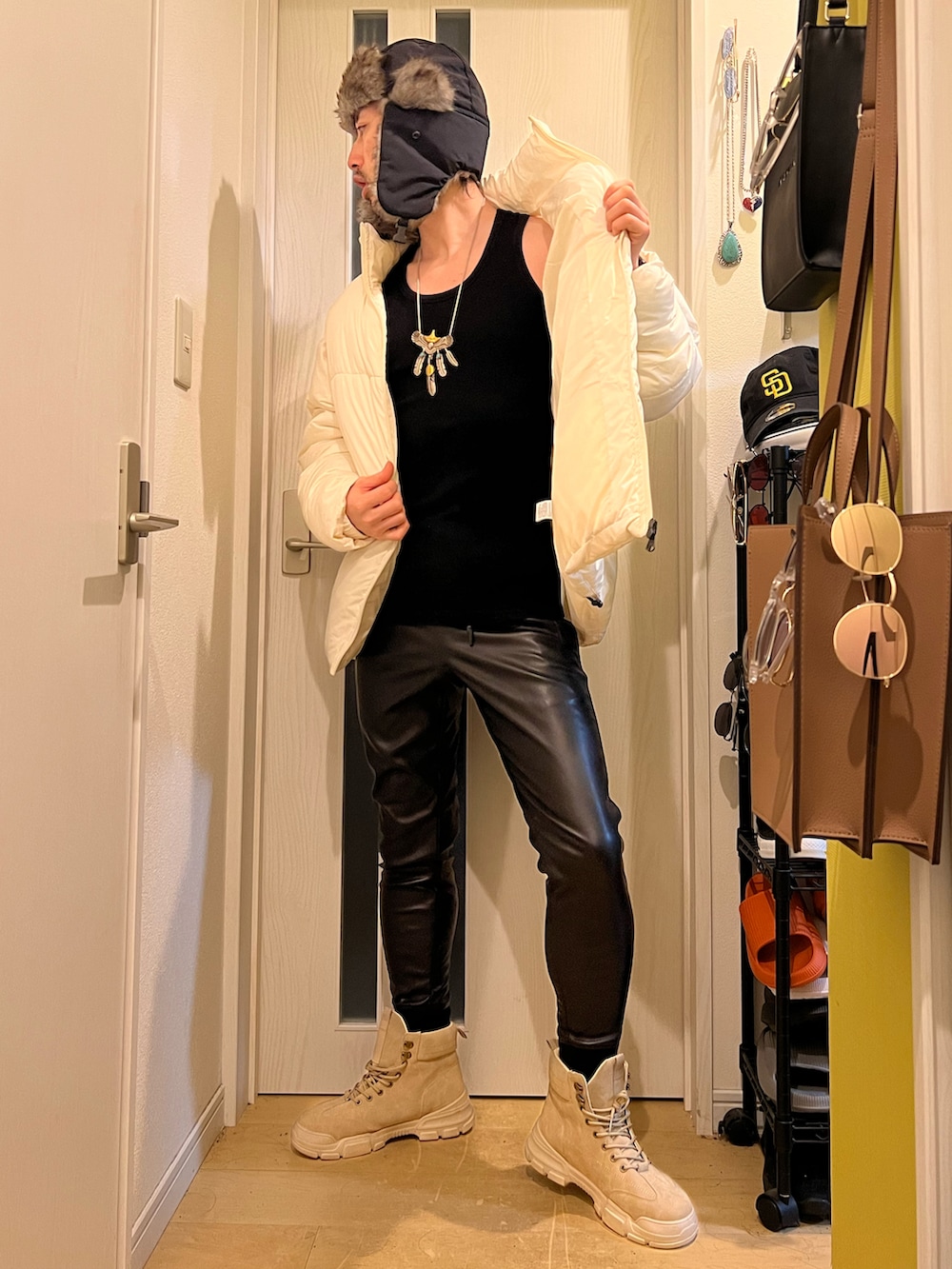 ホワイト系のダウンジャケット/コート、ブラック系のその他パンツ、ブラック系のキャップを着用したメンズの冬コーディネートの4枚目の写真