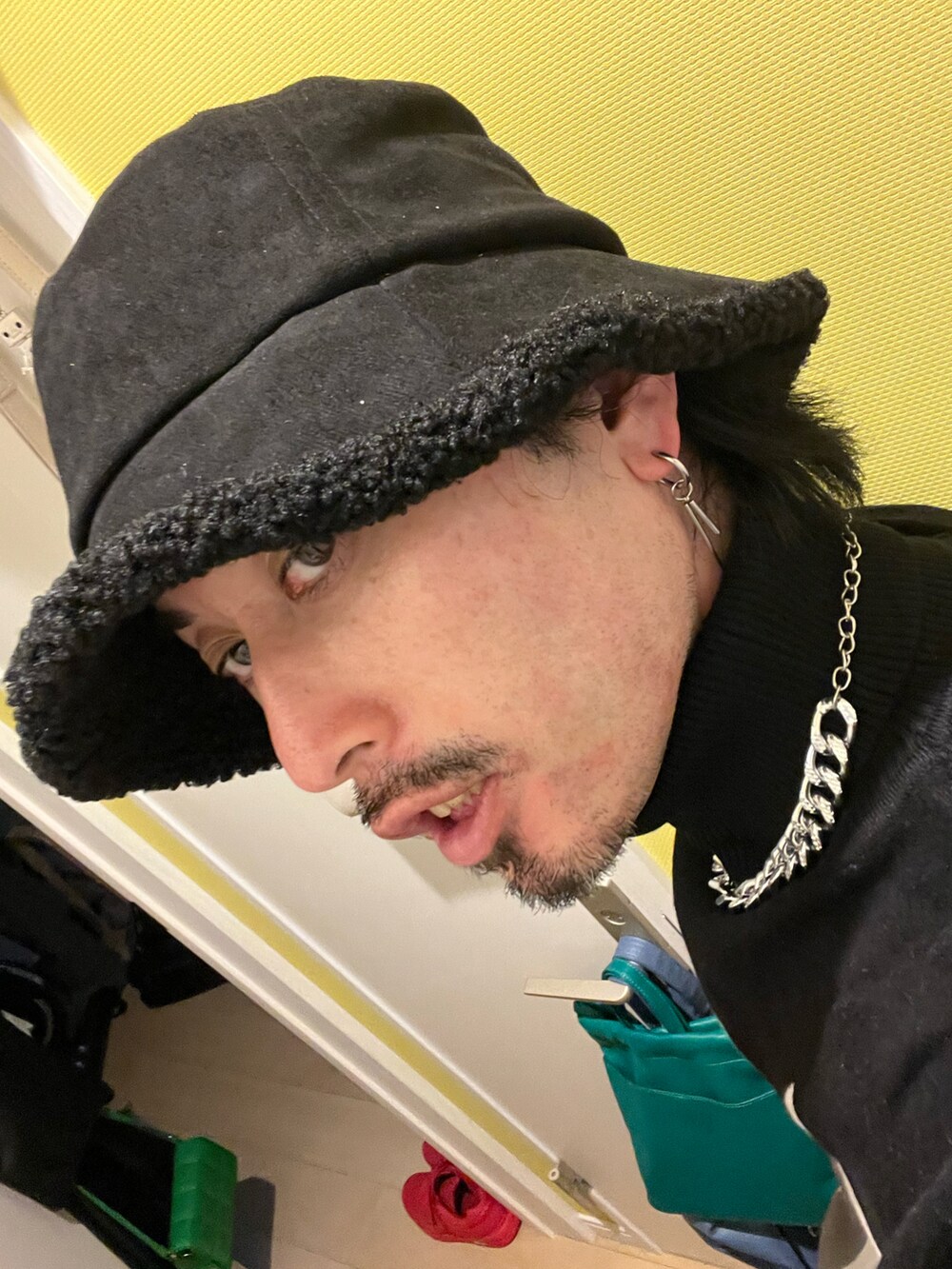 ブラック系のスニーカー、イエロー系のスラックス、ブラック系のニット/セーターを着用したメンズの秋コーディネートの5枚目の写真