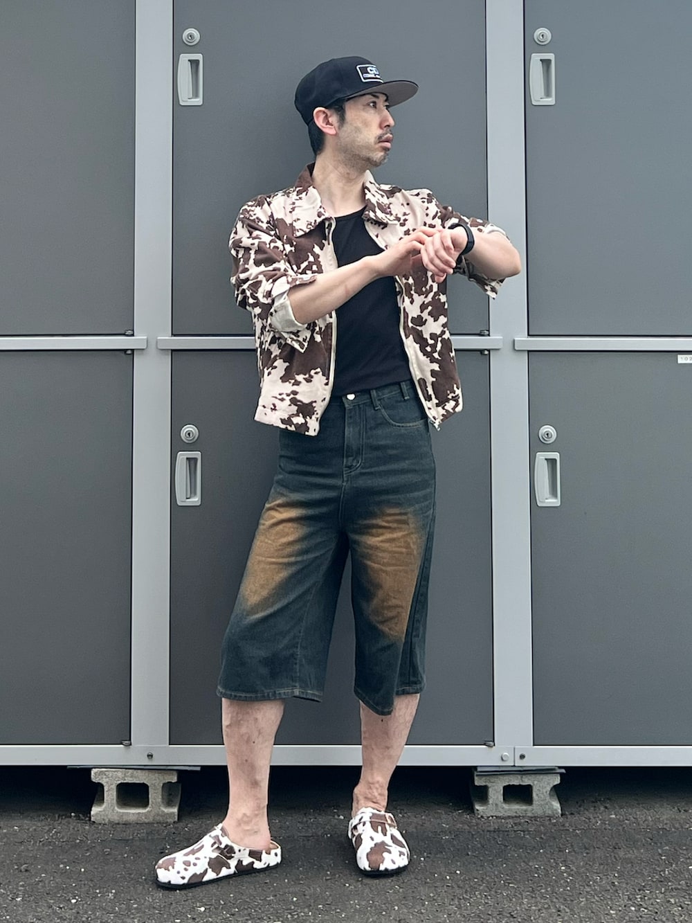 ブラウン系のパンツ、ブラウン系のサンダル、ブラック系のタンクトップを着用したメンズの夏コーディネートの2枚目の写真