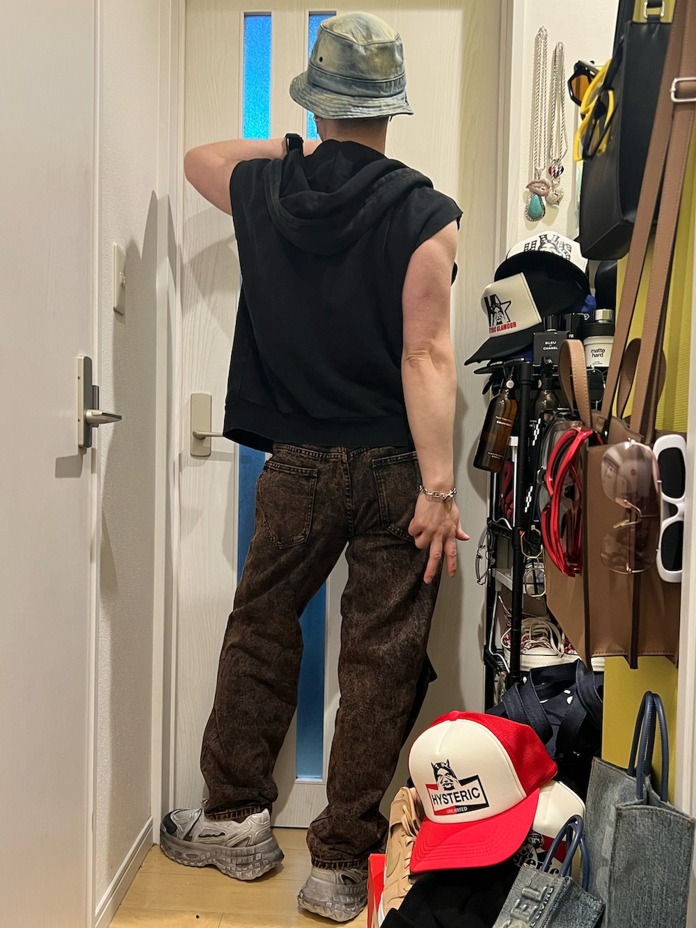 ブラウン系のデニムパンツ、ホワイト系のスニーカー、ホワイト系のボクサーパンツを着用したメンズの春コーディネートの3枚目の写真