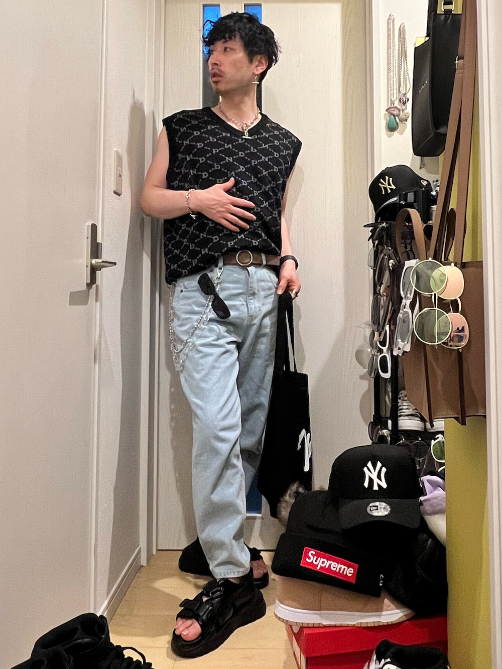 ブルー系のデニムパンツ、ブラック系のサンダル、ブラック系のトートバッグを着用したメンズの春コーディネートの4枚目の写真