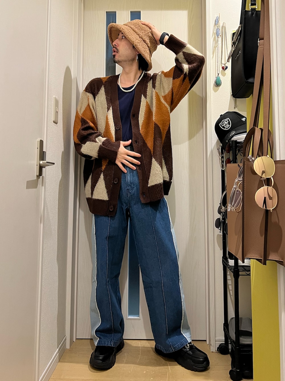 ブラウン系のカーディガン/ボレロ、ブルー系のデニムパンツ、ブラック系のスニーカーを着用したメンズの秋コーディネートの4枚目の写真