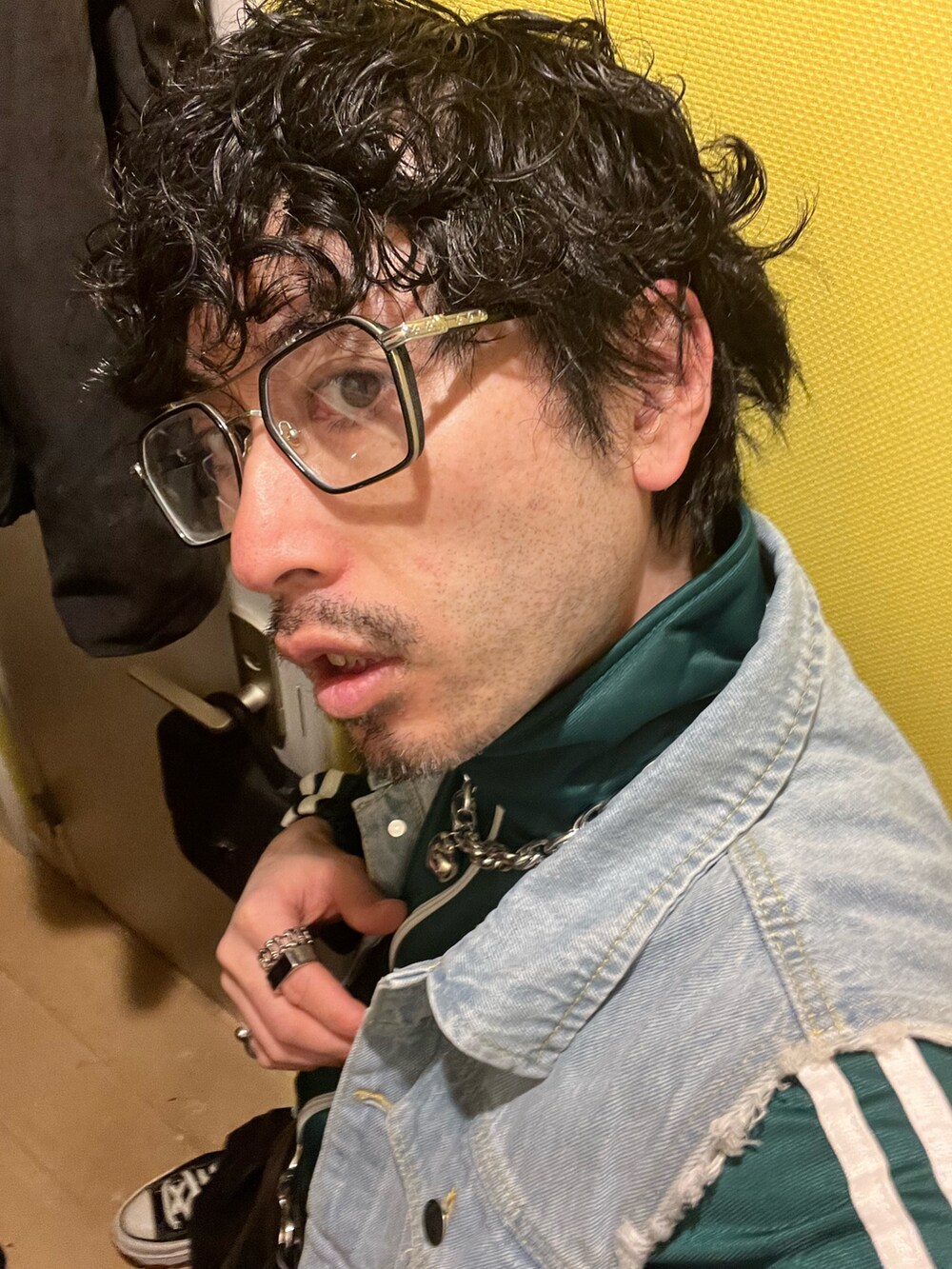 ブラック系のカーゴパンツ、ブラック系のスニーカー、ホワイト系のショルダーバッグを着用したメンズの春コーディネートの4枚目の写真