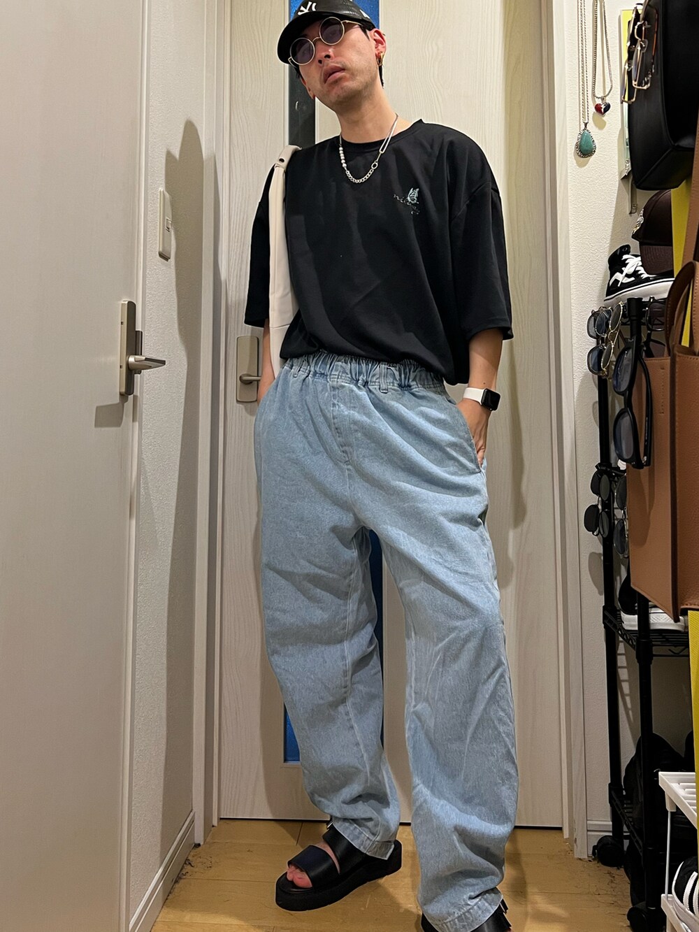 ブルー系のデニムパンツ、ブラック系のサンダル、ホワイト系のトートバッグを着用したメンズの夏コーディネートの2枚目の写真