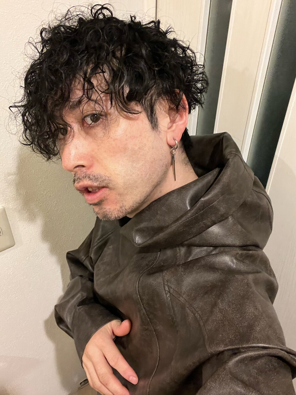 ブラウン系のパーカー、ブルー系のカーゴパンツ、ブラック系のサンダルを着用したメンズの秋コーディネートの5枚目の写真