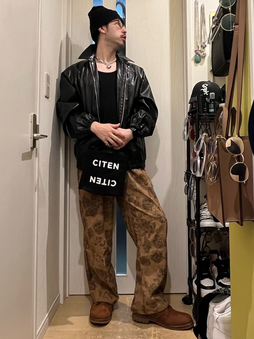 ブラック系のトートバッグ、ブラウン系のその他パンツ、ブラウン系のブーツを着用したメンズの秋コーディネートの2枚目の写真