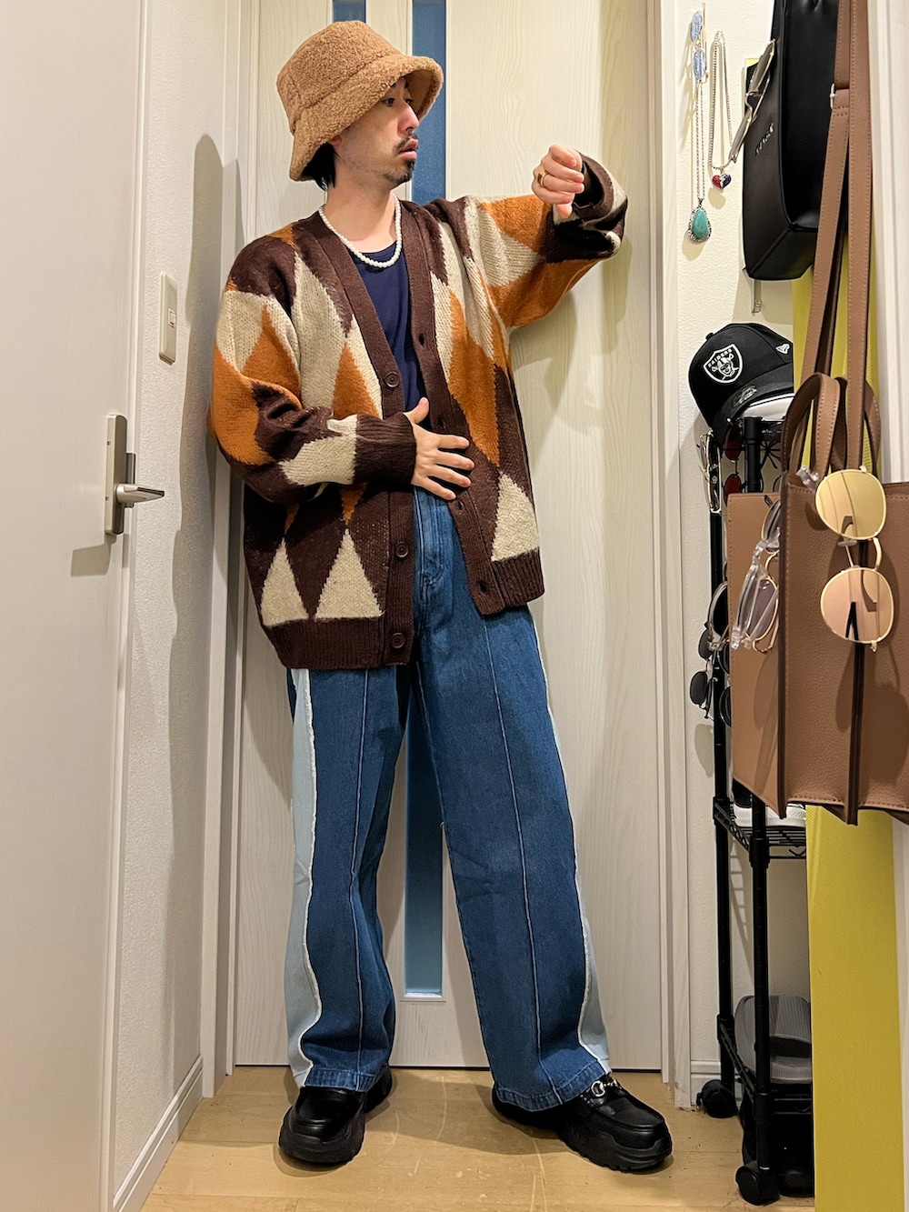 ブラウン系のカーディガン/ボレロ、ブルー系のデニムパンツ、ブラック系のスニーカーを着用したメンズの秋コーディネートの3枚目の写真