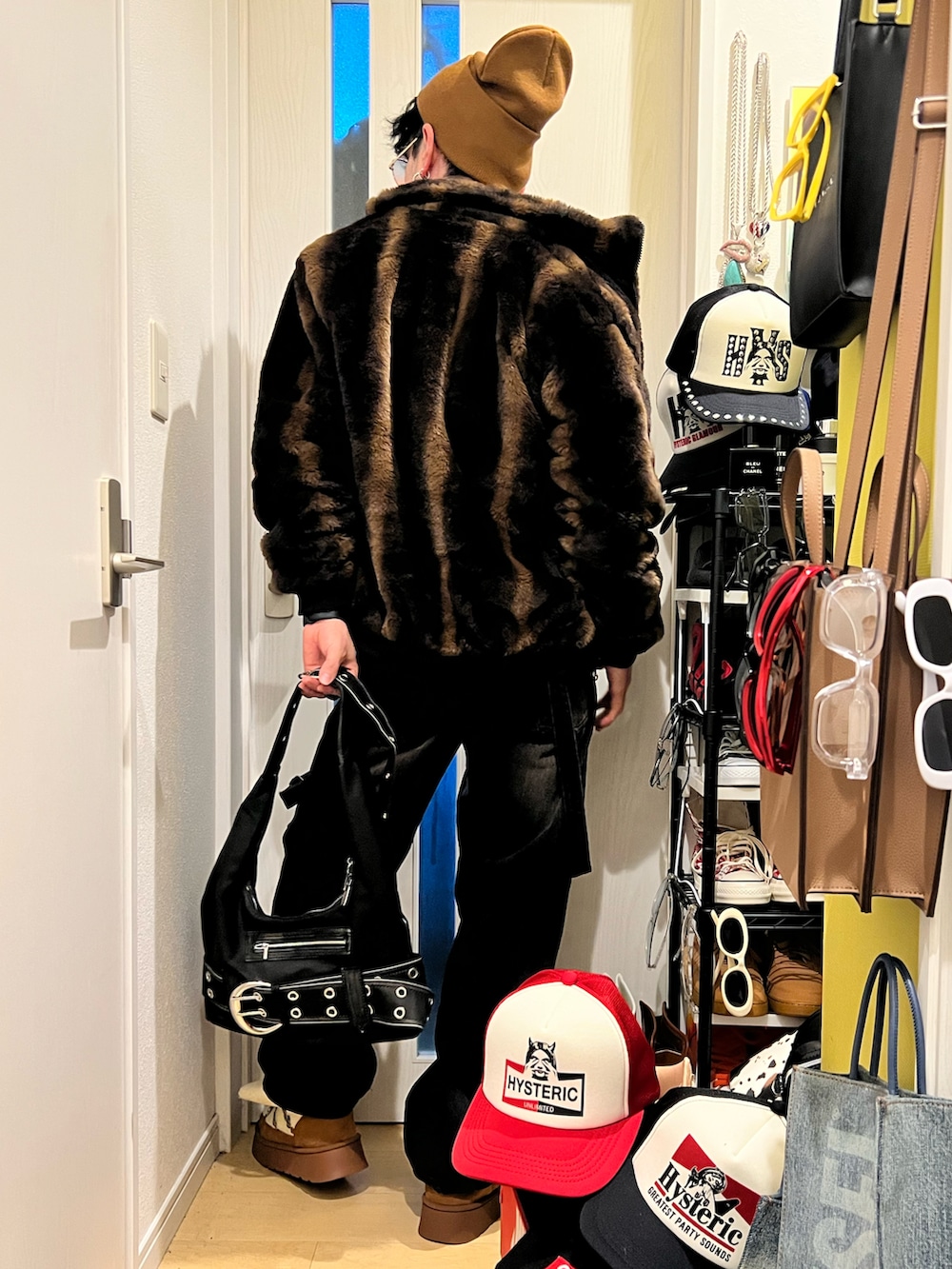 ブラック系のハンドバッグ、ブラック系のデニムパンツ、ブラウン系のブーツを着用したメンズの冬コーディネートの2枚目の写真