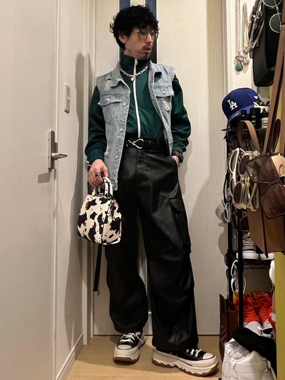 ブラック系のカーゴパンツ、ブラック系のスニーカー、ホワイト系のショルダーバッグを着用したメンズの春コーディネートの2枚目の写真