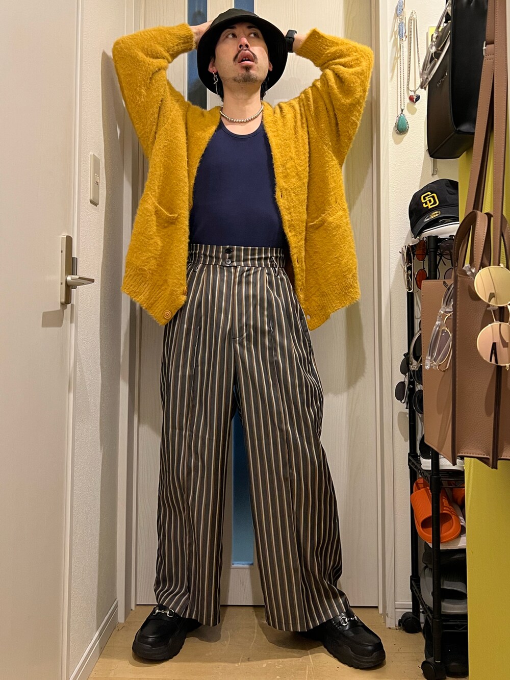 イエロー系のカーディガン/ボレロ、ブラック系のその他パンツ、ブラック系のスニーカーを着用したメンズの秋コーディネートの3枚目の写真