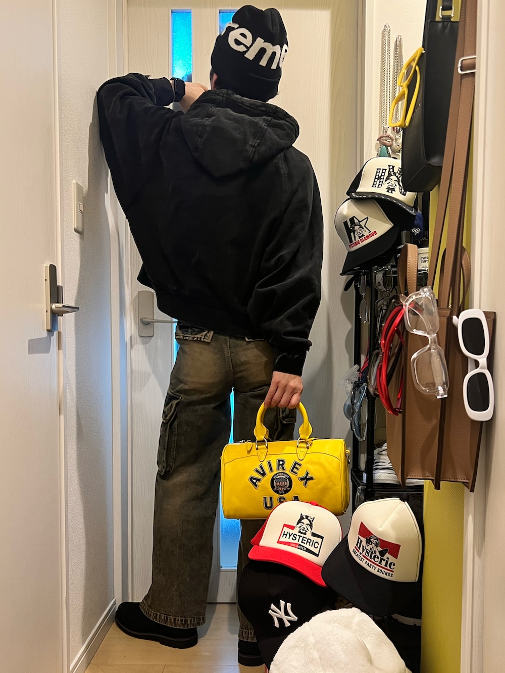 イエロー系のボストンバッグ、ブルー系のカーゴパンツ、ブラック系のブーツを着用したメンズの冬コーディネートの3枚目の写真