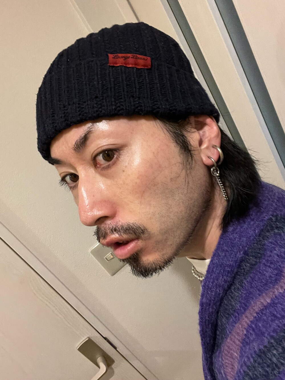 ブラック系のブーツ、パープル系のカーディガン/ボレロ、ホワイト系のその他パンツを着用したメンズの冬コーディネートの3枚目の写真