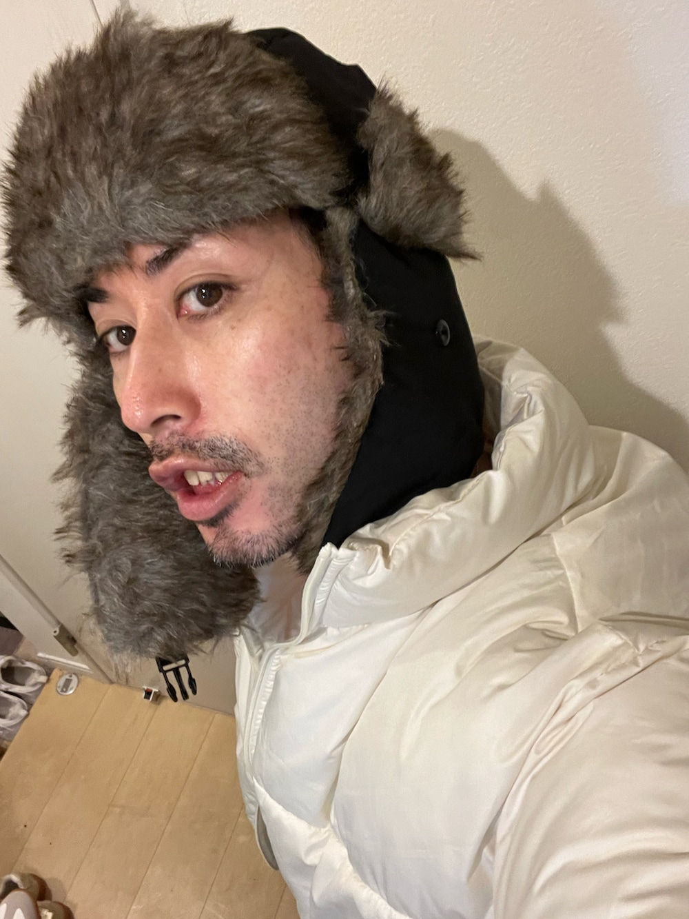 ホワイト系のダウンジャケット/コート、ブラック系のその他パンツ、ブラック系のキャップを着用したメンズの冬コーディネートの5枚目の写真
