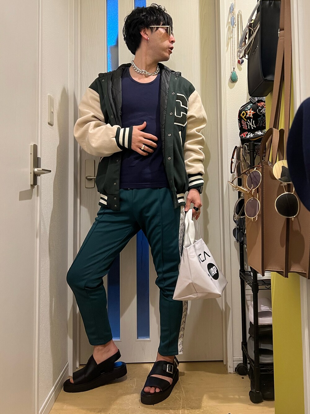 ホワイト系のトートバッグ、グリーン系のその他パンツ、ブラック系のサンダルを着用したメンズの春コーディネートの3枚目の写真